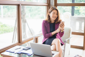 Singapore Resident submitting loan application on phone and laptop